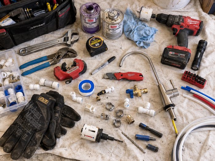 Plumber's toolkit laid out before a water softener install